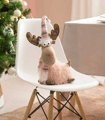 Figura de natal em forma de rena em cima de uma cadeira